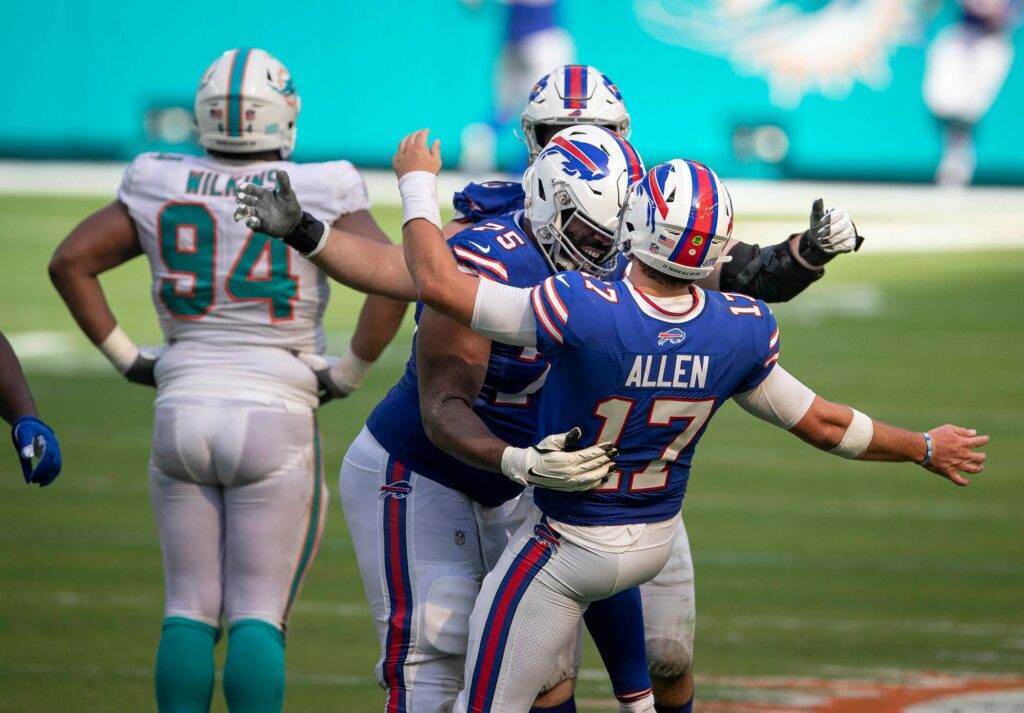 Buffalo Bills quarterback Josh Allen celebrates a long touchdown pass with offensive tackle Daryl Williams as Dolphins defensive tackle Christian Wilkins watches the play downfield. Wilkins has been one of the few bright spots on the defensive line for Miami thus far.