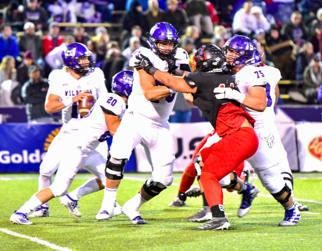 Ty Whitworth, number 75, Josh Davis, number 20 move work together to move the ball. (Nikki Dorber / The Signpost)