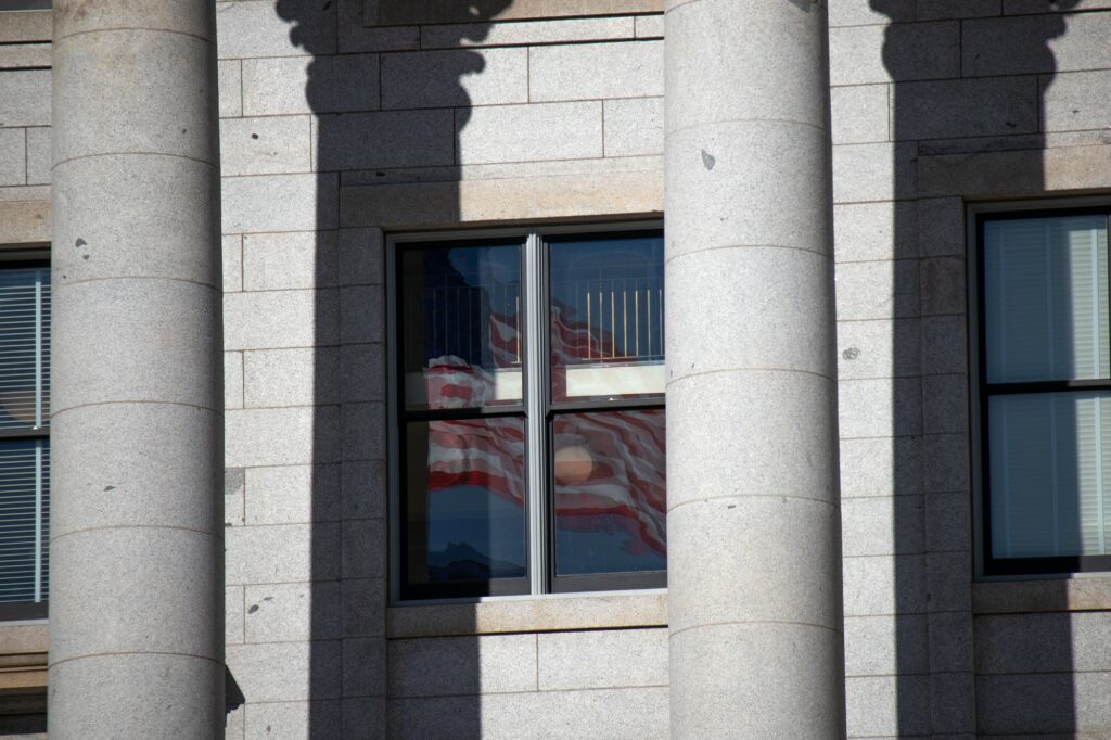 Flag reflects in window at Utah State Capital on Jan. 22. (Sarah Earnshaw/ The Signpost)