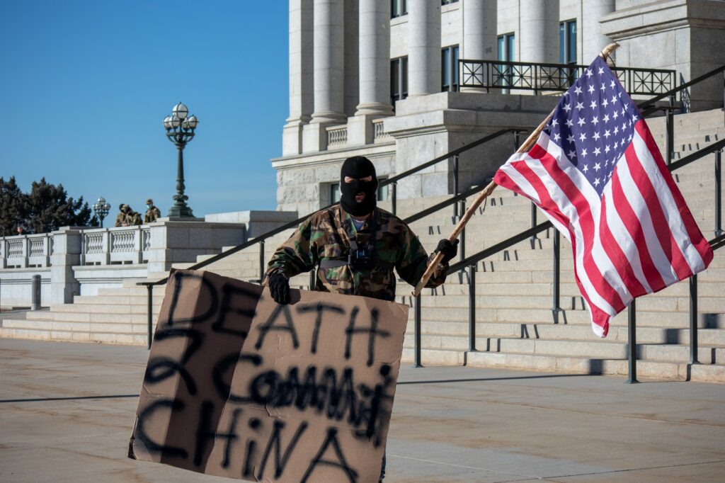 Protestor stands at foot of steps at Utah State Capitol (Sarah Earnshaw/ The Signpost)