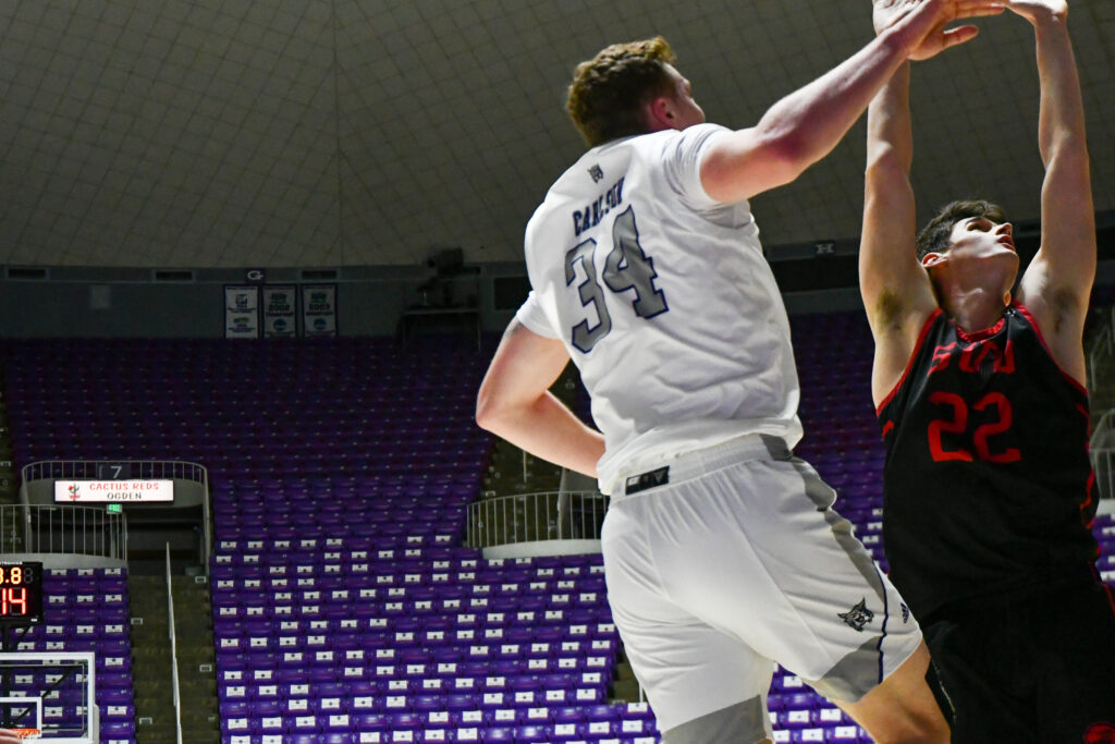 Cody Carlson, #34, Center for WSU goes up for the rebound during Thursday's game at Weber's Dee Event Center. (Nikki Dorber / The Signpost)
