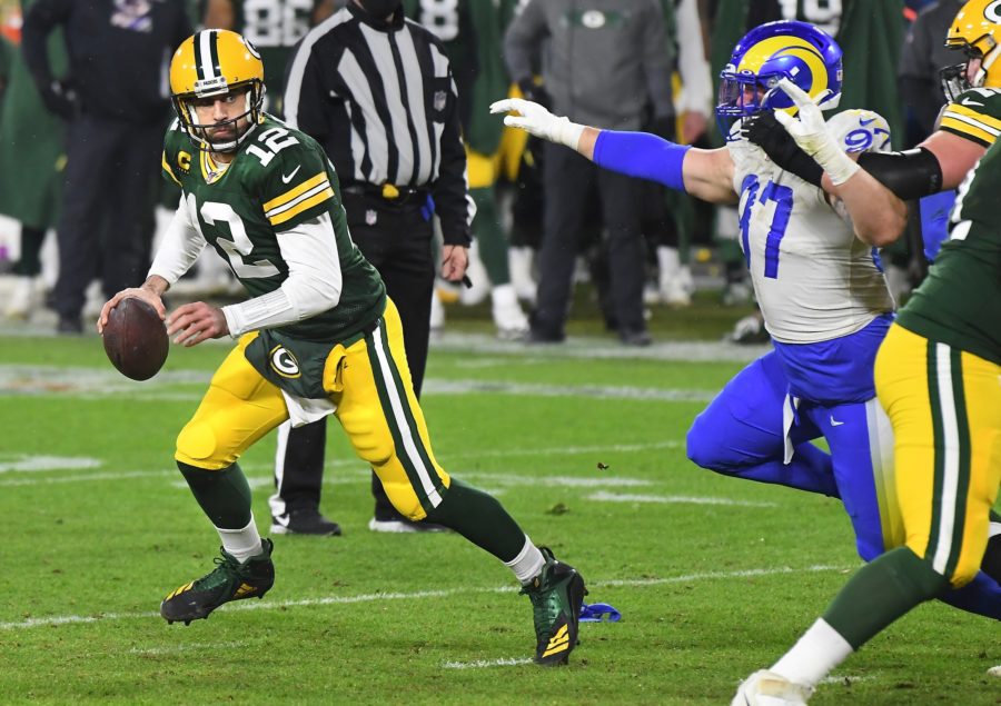 Green Bay Packers quarterback Aaron Rodgers (12) looks for a receiver as Los Angeles Rams defensive lineman Morgan Fox (97) pursues during an NFC Divisional playoff game at Lambeau Field in Green Bay, Wisconsin, on Jan. 16, 2021. The Packers advanced, 32-18. (Wally Skalij/Los Angeles Times/TNS)