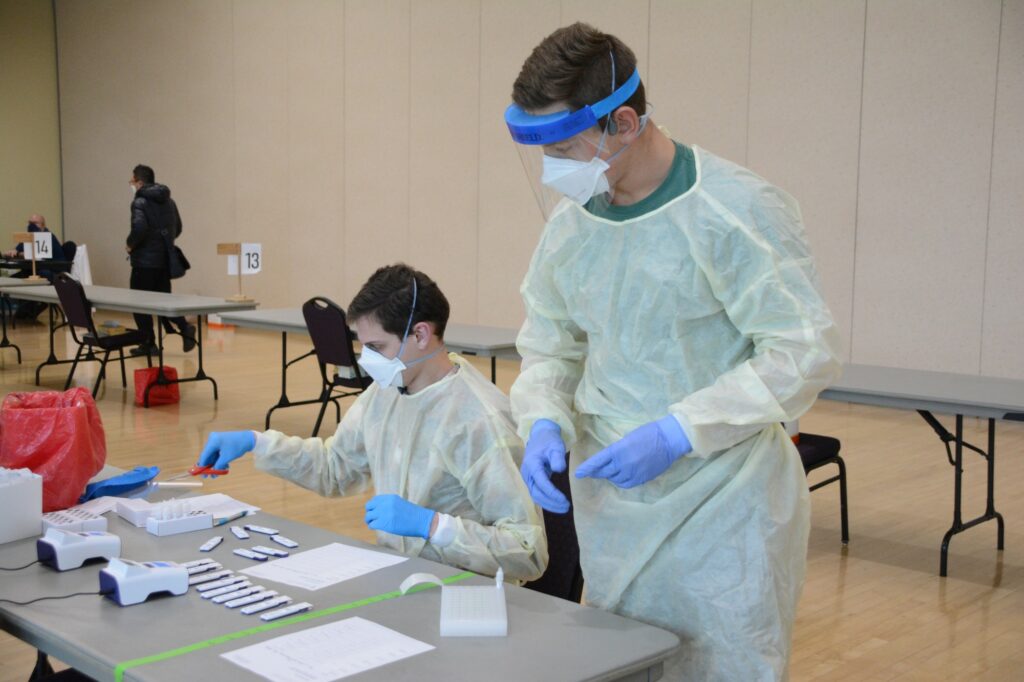 Health care professionals sort and label finished testing materials. (Brooklynn Kilgore/The Signpost)