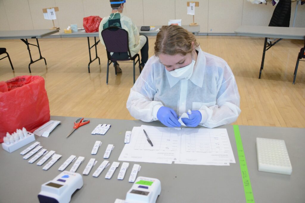 Health care professional and student, Amy Lund, labels and sorts completed testing materials. (Brooklynn Kilgore/The Signpost)