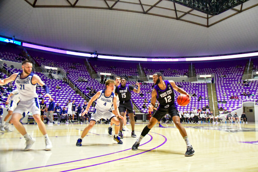 Weber State's Isiah Brown, number 12, preparing to set for a three pointer in Saturday's game against Northern Arizona.  (Nikki Dorber / The Signpost)