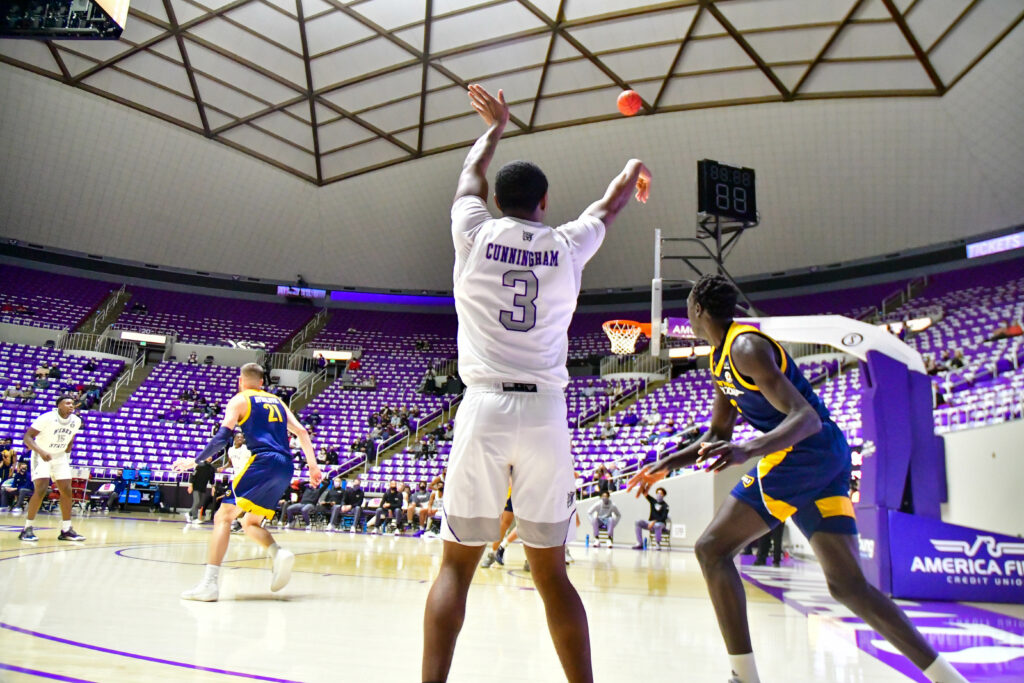 Cunningham, a forward for Weber State University Men's Basketball, throws in a three pointer on Thursday's game against Northern Arizona.  WSU wins 92 to 59.  (Nikki Dorber / The Signpost)
