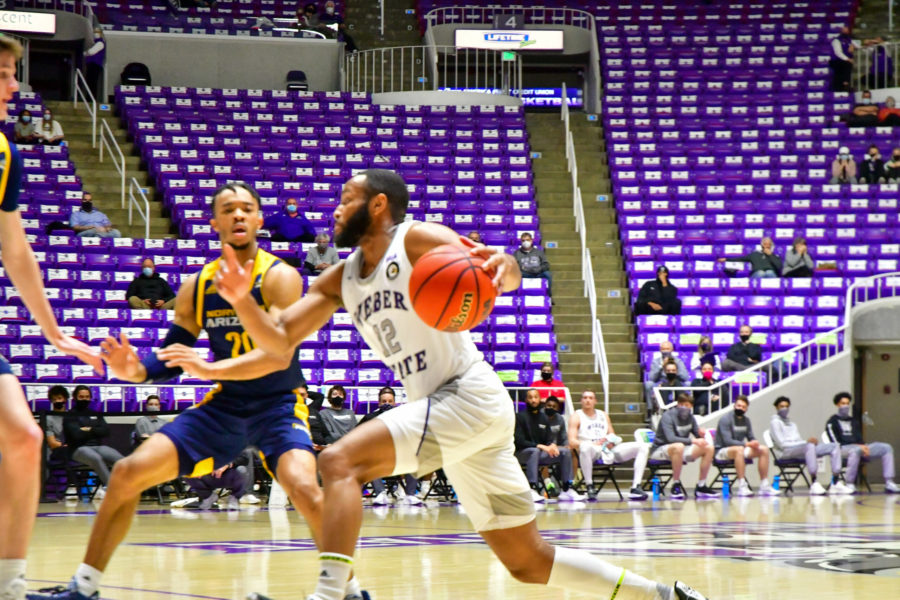 Weber State Universitys Isiah Brown, 12, goes up against two Northern Arizona University players in an attempt to keep the lead. (Nikki Dorber / The Signpost)