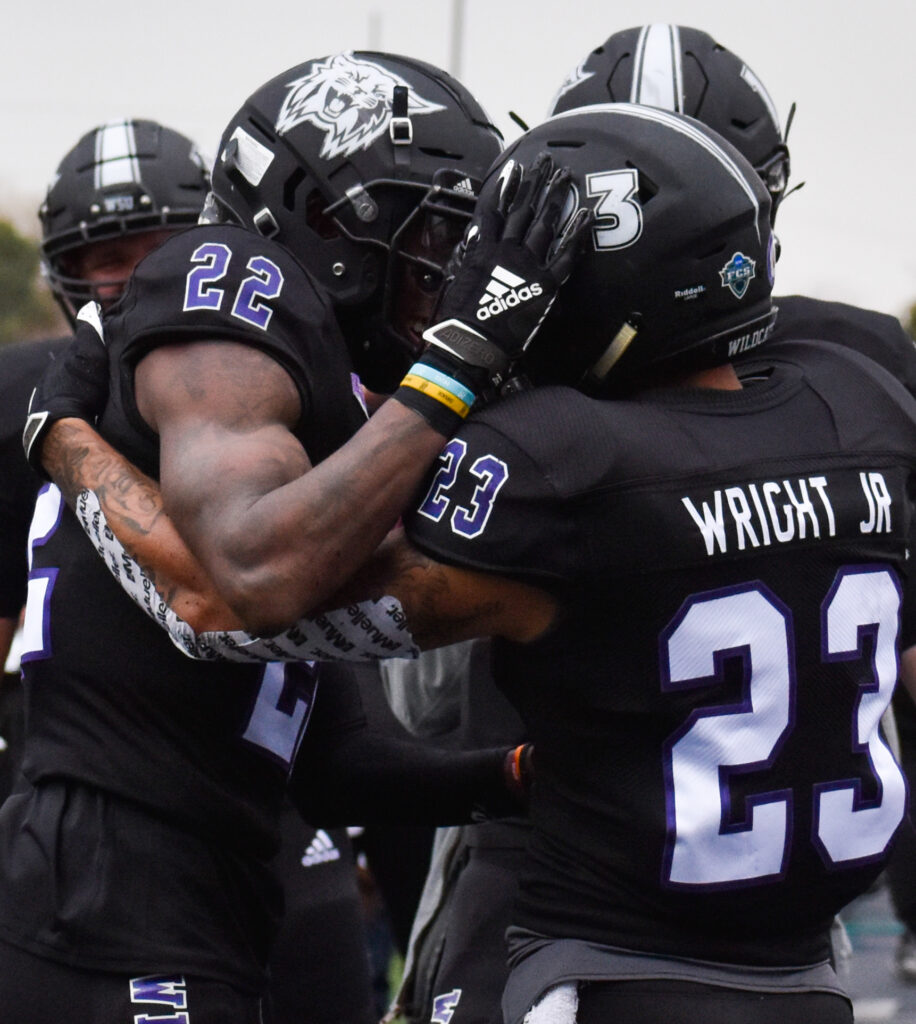 Helmet bumps between two Weber State University football players on Saturday at Stewart Stadium. (Paige McKinnon/The Signpost)