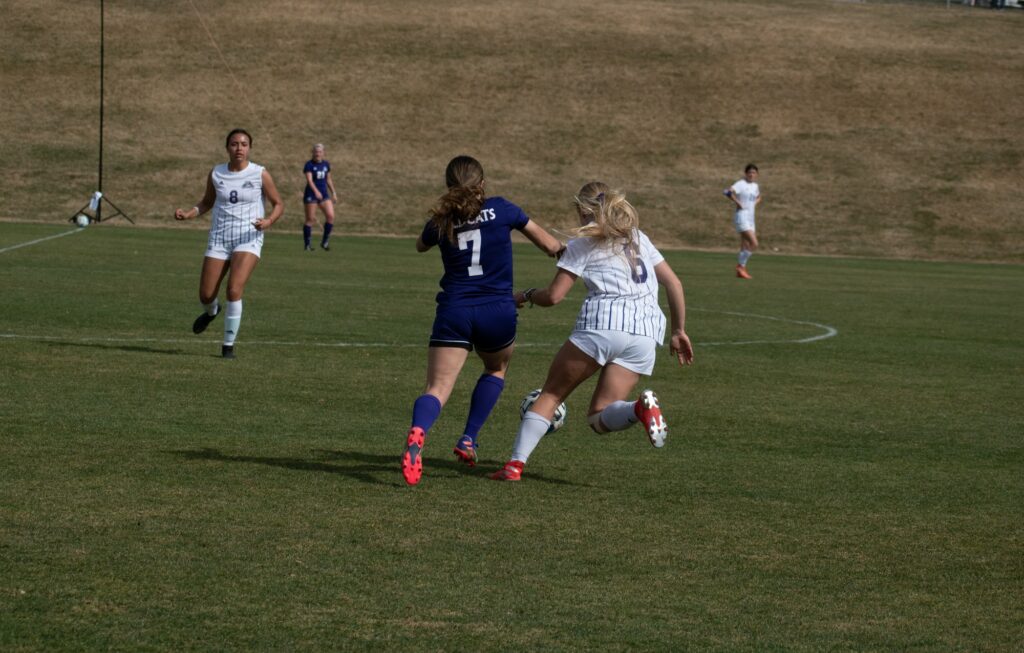 Two wildcat players, on different teams for their scrimmage, go head to head for the ball. (Paige McKinnon/The Signpost)