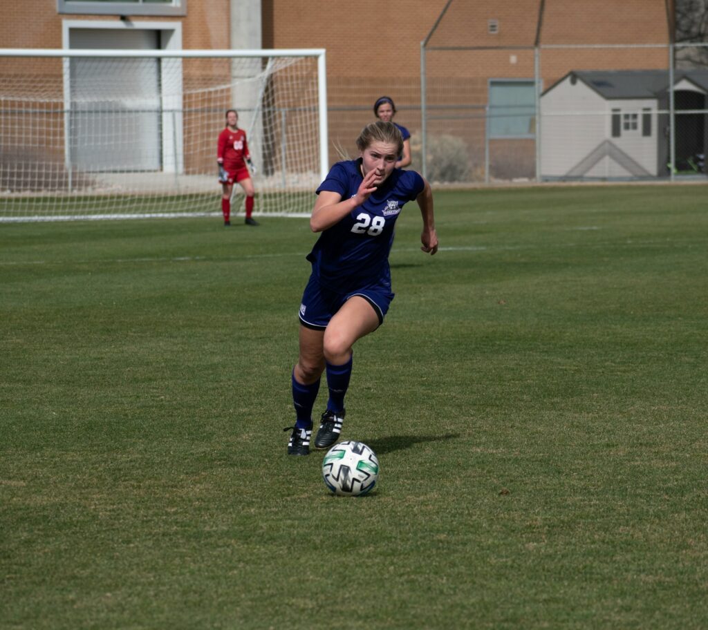Wildcat soccer player, number 28, dribbles the ball down the Weber State soccer field on March 19. (Paige McKinnon/The Signpost)