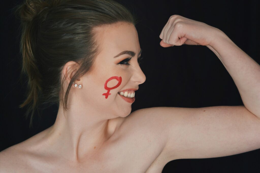 Brooklynn Kilgore flexes her bicep, bearing a female symbol on her cheek, Sunday, Mar. 14, 2021, in Ogden, Utah. (Brooklynn Kilgore/The Signpost)