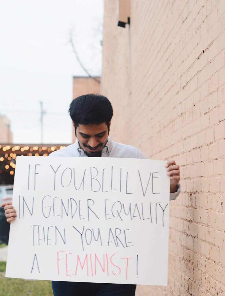 Azzam holds a sign reading "If you believe in gender equality then you are a feminist!," Sunday, Mar. 14, 2021, in Ogden, Utah.