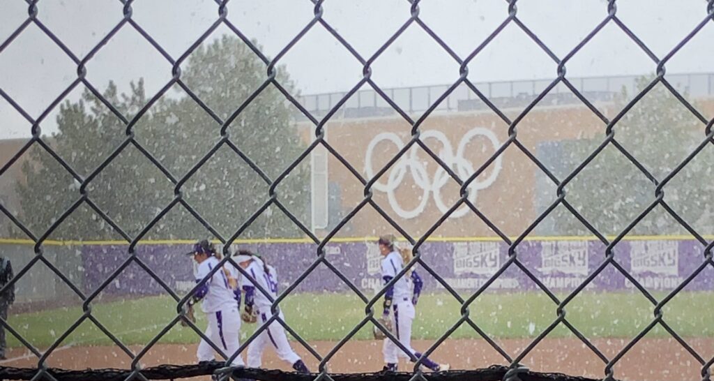 Wildcat softball players running to the dugout as snow falls forcing the game to be canceled in Ogden on March 23.
