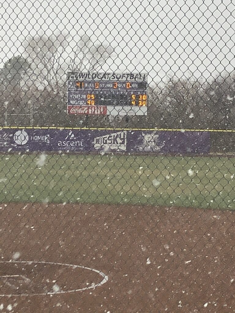 Snow falling at Wildcat softball field after the game was canceled due to the weather.