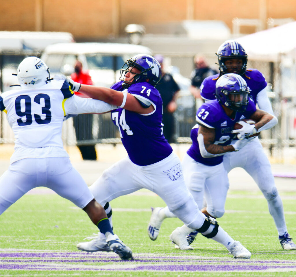 Weber State University's offensive lineman George Barrera protects running back Daniel Wright Jr. as he gains yards during one of many drives during the game against Northern Arizona University on Saturday, March 27. Nikki Dorber/The Signpost