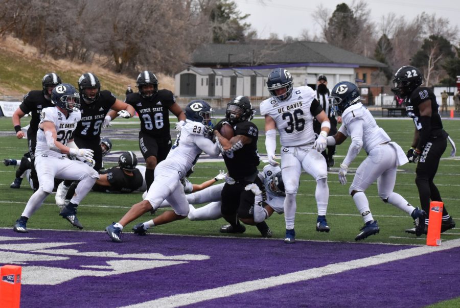 Weber State football player Daniel Wright Jr. makes a touchdown despite the pushback from the Aggies. (Paige McKinnon/The Signpost)