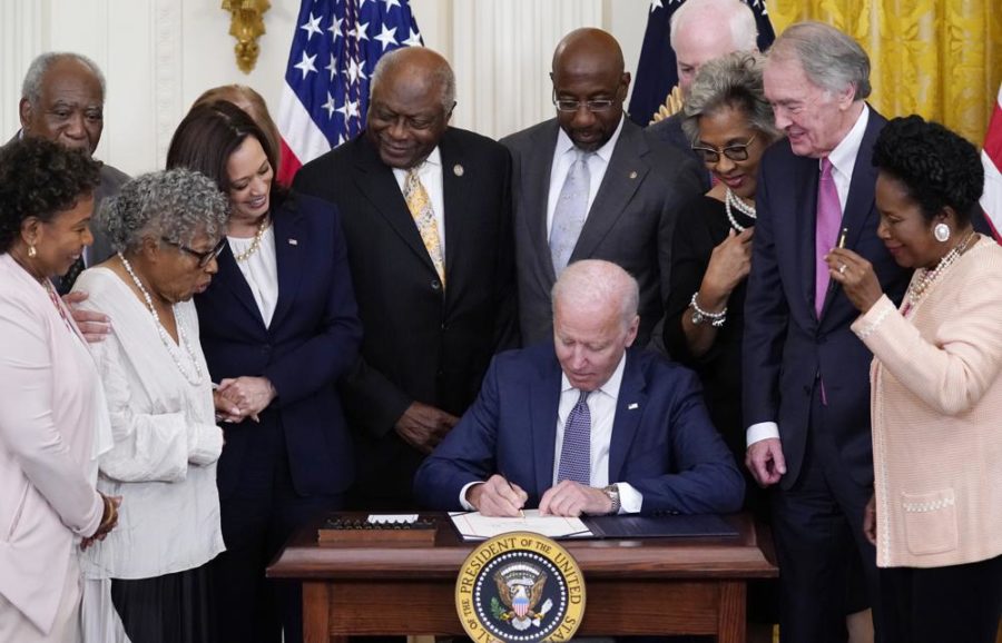 President Joe Biden signs the Juneteenth National Independence Day Act on Thursday, June 17, 2021, surrounded by members of the Congressional Black Caucus as well as the lead sponsors of the legislation in the Senate. (Evan Vucci / AP Photo)