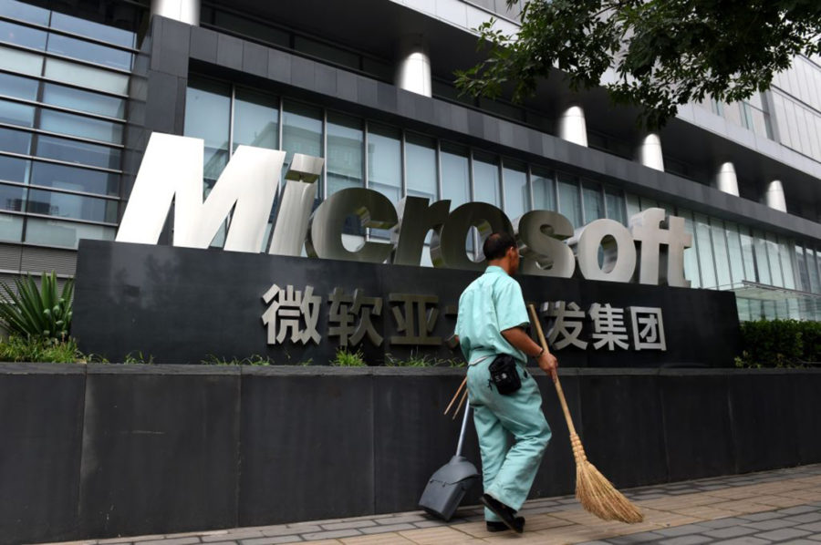 A cleaner walks past a Microsoft sign outside a Microsoft office building in Beijing on July 31, 2014. Photo credit:  (Greg Baker/AFP via Getty Images/TNS)