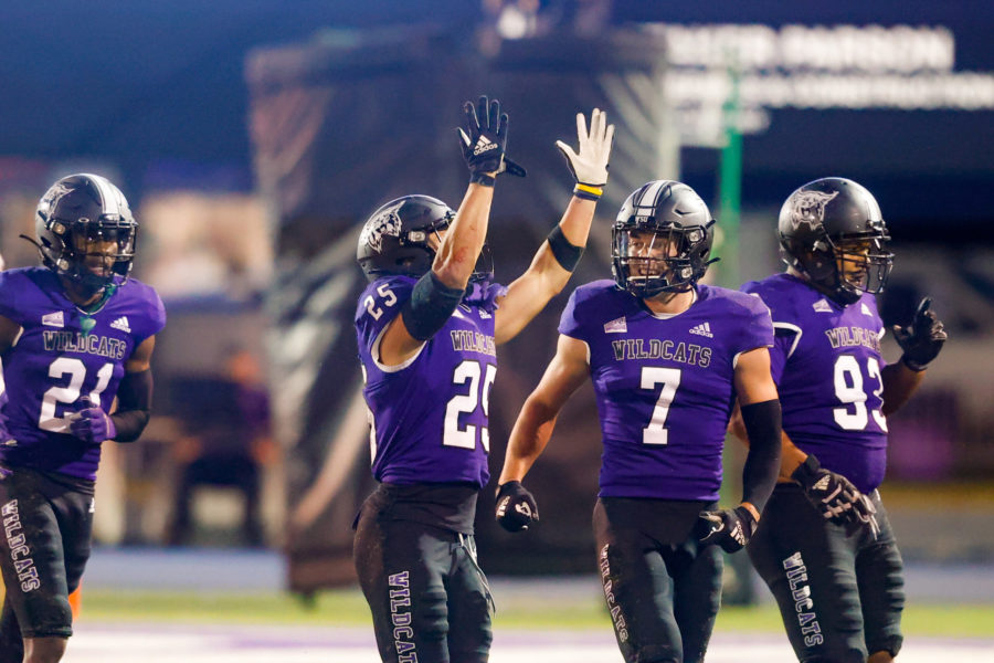 Wildcat safety Braxton Gunther, 25, celebrates with his teammates safety Preston Smith, 7, cornerback Maxwell Anderson, 21, and Sione Lapuaho, 93, following his interception against UC Davis on Sept. 25, at Stewart Stadium. Photo credit: Robert Casey / Weber State Athletics