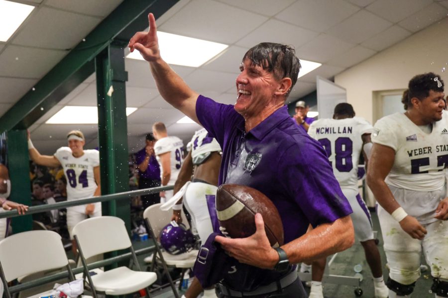 Wildcat head coach Jay Hill celebrates his record setting 54th win with his team in the locker room, following Weber States 38-7 win. Photo credit: Robert Casey / Weber State Athletics