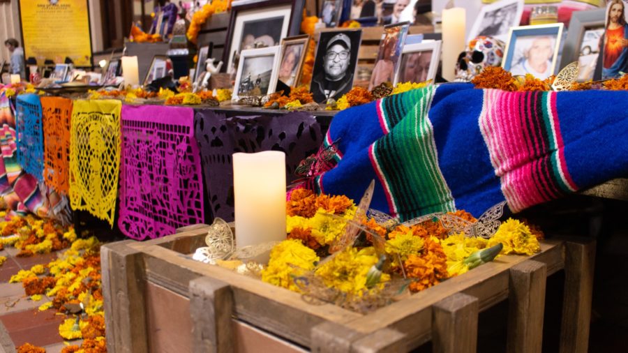 Many photos of loved ones who have passed are set up on decorated tables, along with flowers and other colorful decorations, to remember those who have passed and to bring them back to the living world on the Day of the Dead. (Kennedy Robins/ The Signpost) Photo credit: Kennedy Robins