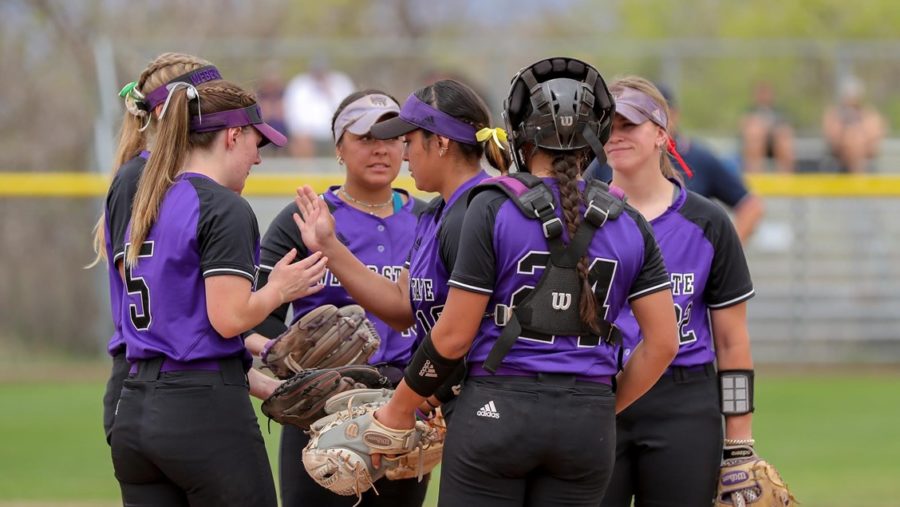 The Wildcats huddle together at the mound as the game gets ready to begin. Photo credit: Weber State Athletics