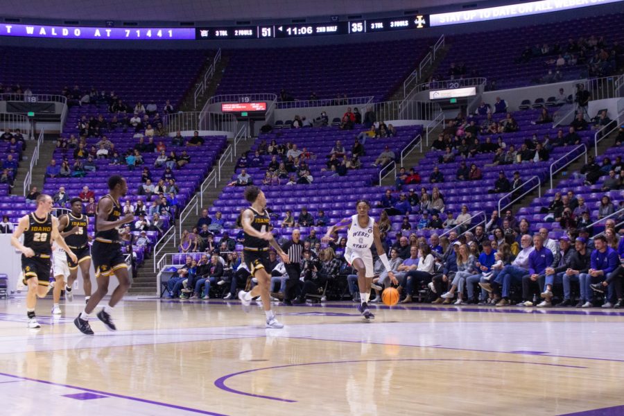 Staying away from Idaho players, Zahir Porter dribbles the basketball toward Weber State players. Photo credit: Kennedy Robins