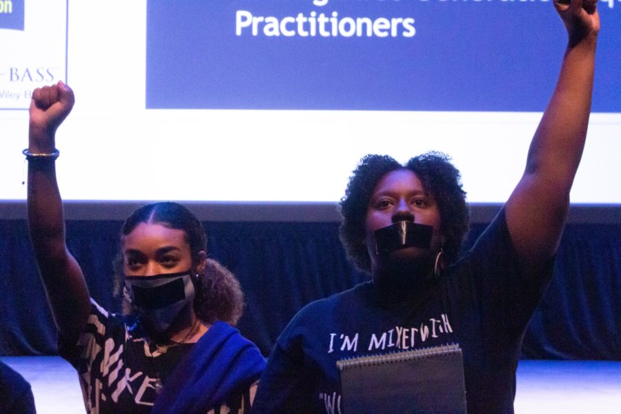 Terri Hughes and Myniah Vaa take part in a protest about racial equality by pumping their fists in the air at the end of Hughes protest speech. Photo credit: Kennedy Robins