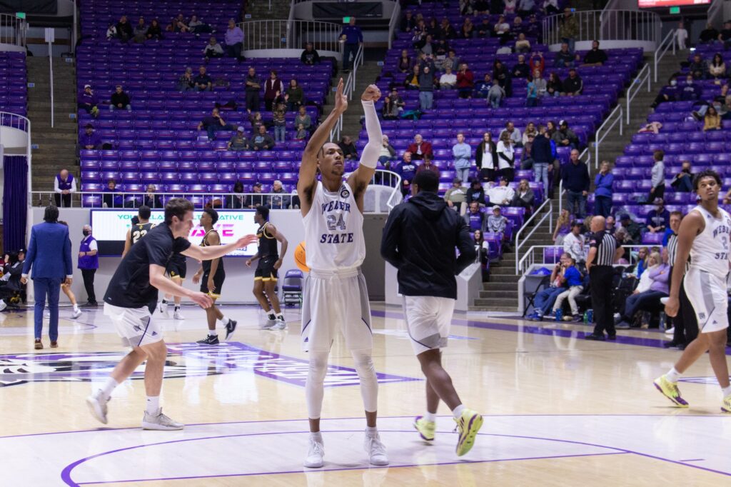 Practicing for the basketball game, JJ Overton watches as his basketball goes into the basketball hoop's net.