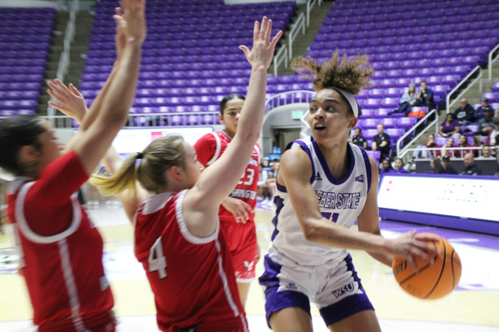 Two Eastern Washington University players try blocking Weber State's Daryn Hickok as she looks for openings to progress towards the hoop.