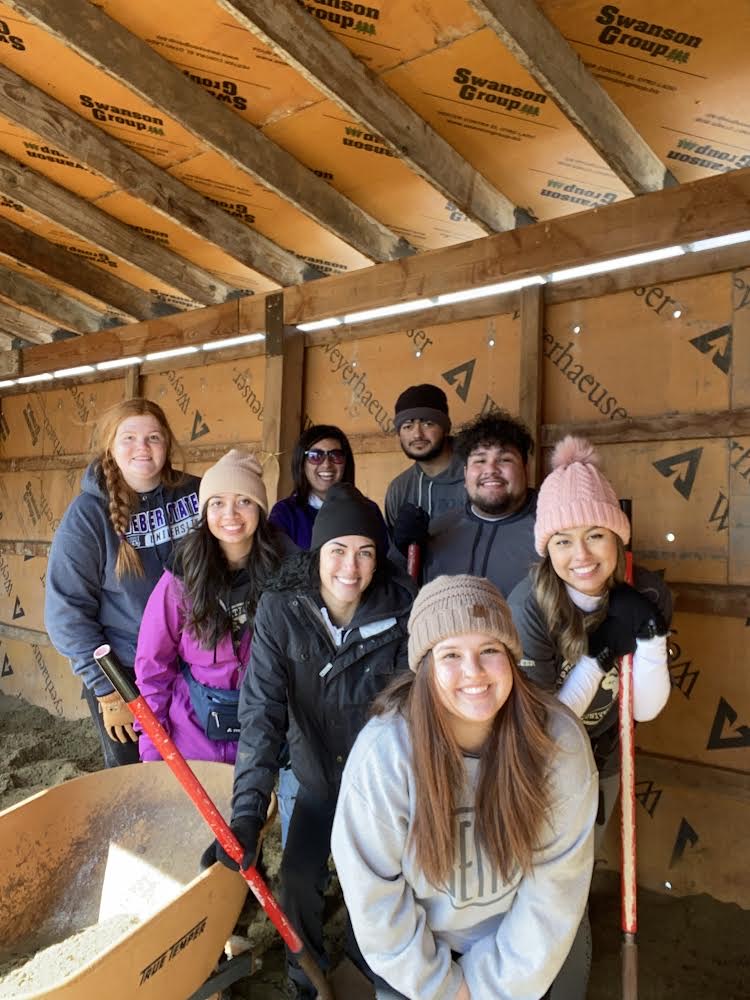 Weber Students are seen cleaning up and prepping the new goat shelter.