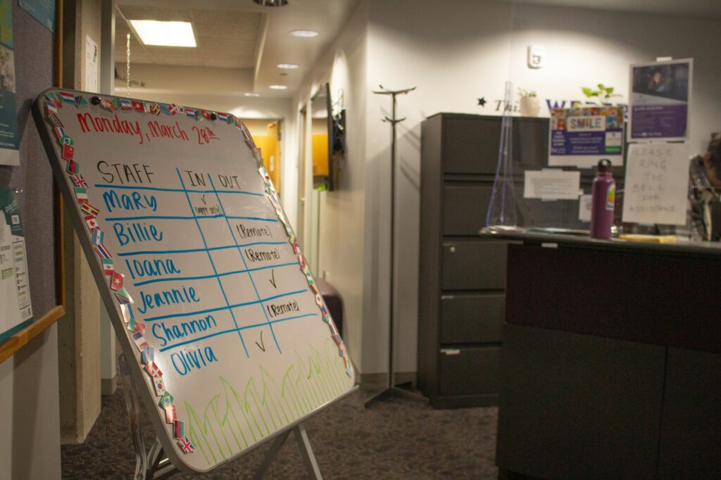 The staff at the International Student and Scholar Center works with the students at WSU, their information on a white board stating they work both remotely and in-person. (Kennedy Robins/ The Signpost)