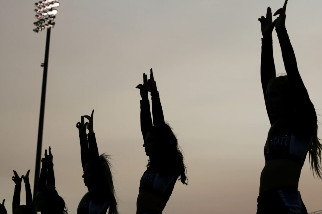 The Wildcat&squot;s cheer team line up for kick off with their "W&squot;s" up high. (Bella Torres / The Signpost)