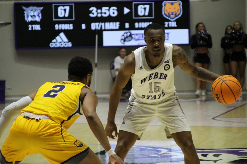 Koby McEwen eyes his teammates and possible openings to get Weber State some points. (Summer Musster/The Signpost)