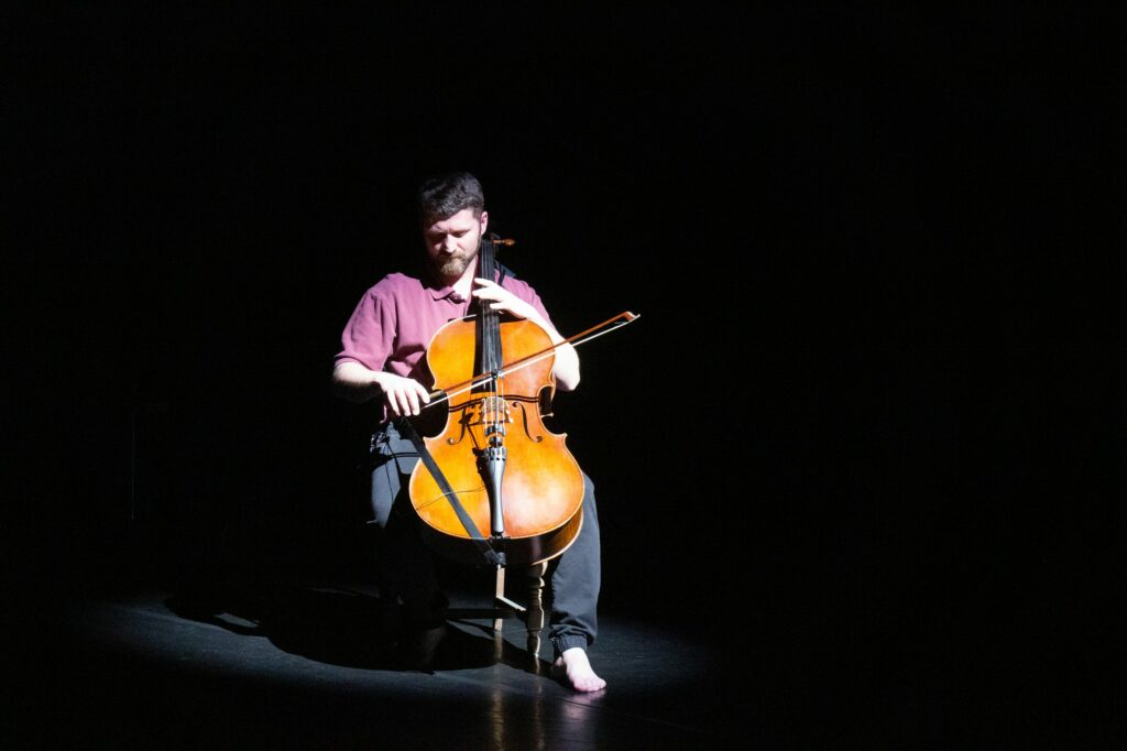 Live accompanist Dan Pack playing his cello in the beginning of "Beautiful Souls", choreographed by Paul Wright.