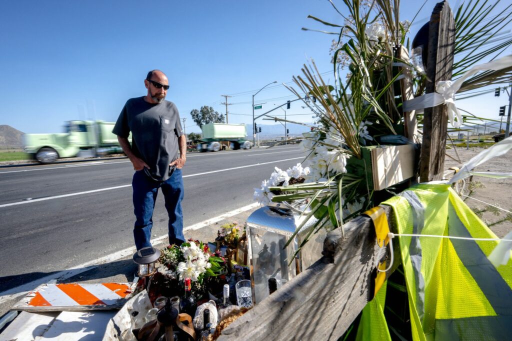Chuck Santone stands near a roadside memorial near the intersection of the Ramona Expressway and Hansen Avenue in Nuevo on April 7. Residents are concerned about recent fatal car accidents on the highway and are calling on the CHP to bolster patrols and enforcement in the area. (Photo by Watchara Phomicinda, The Press-Enterprise/SCNG)