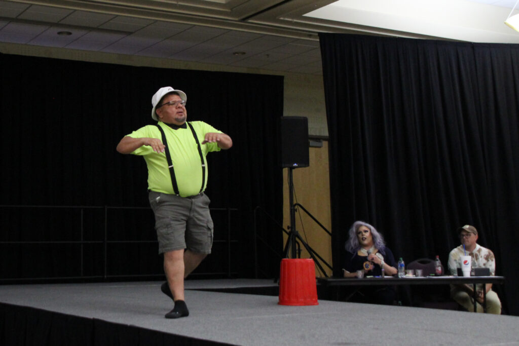 The Phantom dances across the stage as the panel watches. (Summer Muster/The Signpost)