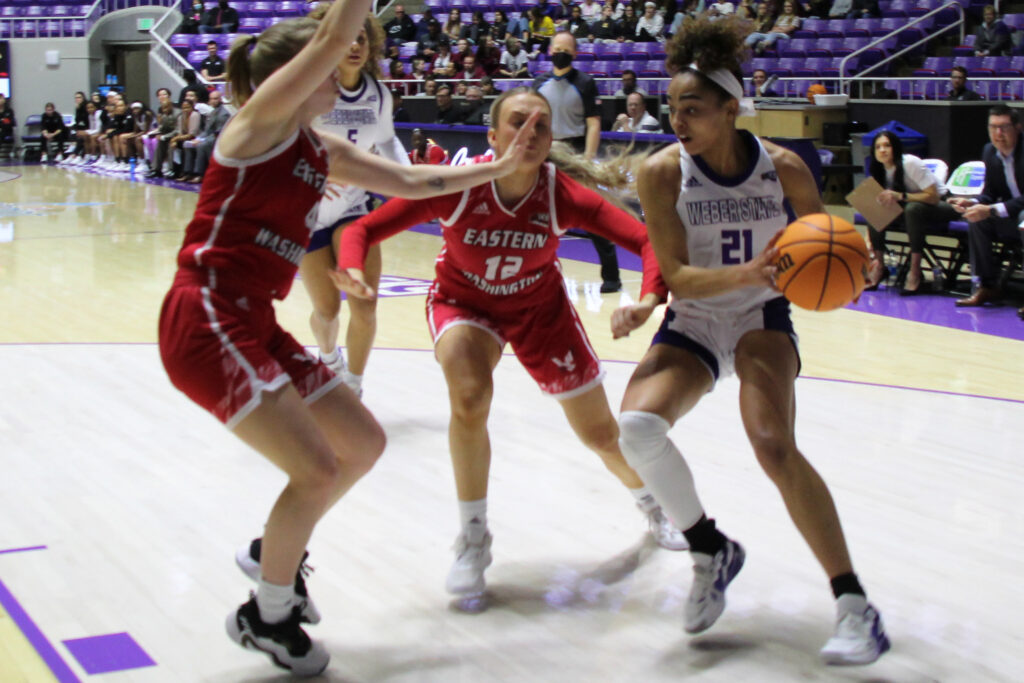 Daryn Hickok goes head-to-head with two EWU players trying to stop her progress toward the basket. (Summer Muster/The Signpost)