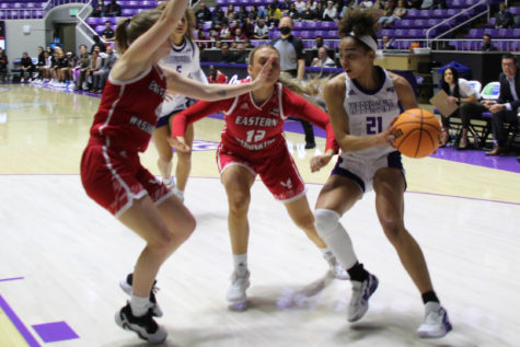 Daryn Hickok goes head-to-head with two EWU players trying to stop her progress toward the basket. Photo credit: Summer Muster