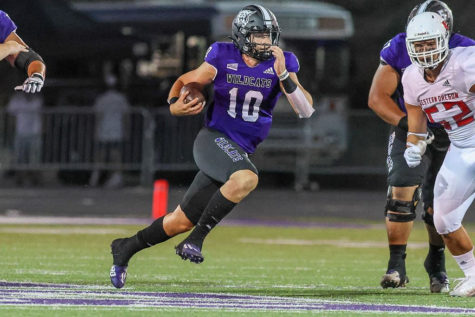 Bronson Barron running on the football field with a football tucked into his arm. (Weber State Athletics)
