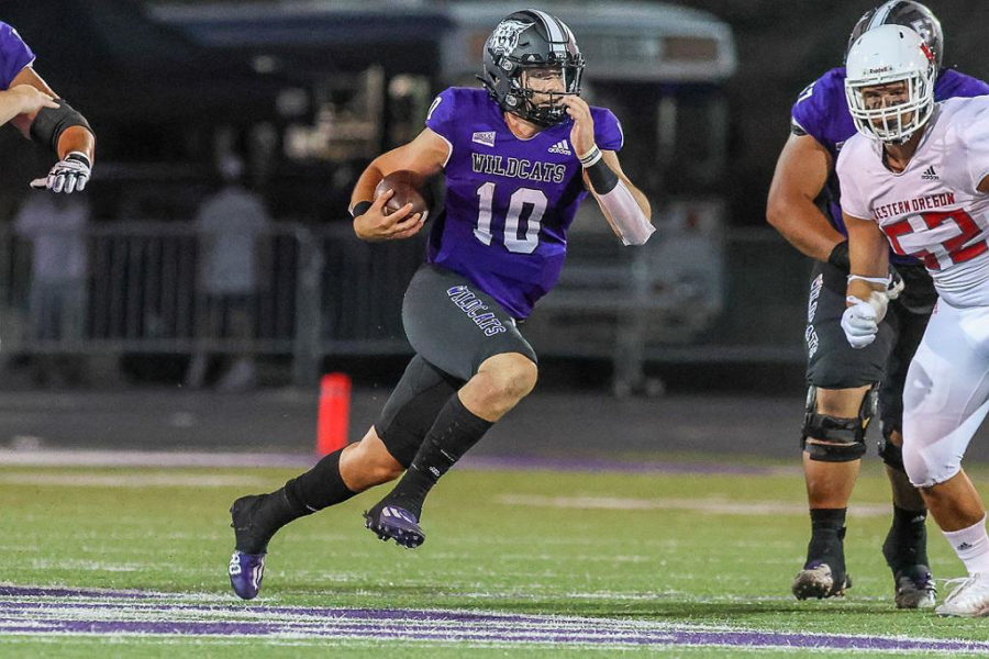 Bronson Barron running on the football field with a football tucked into his arm. (Weber State Athletics)