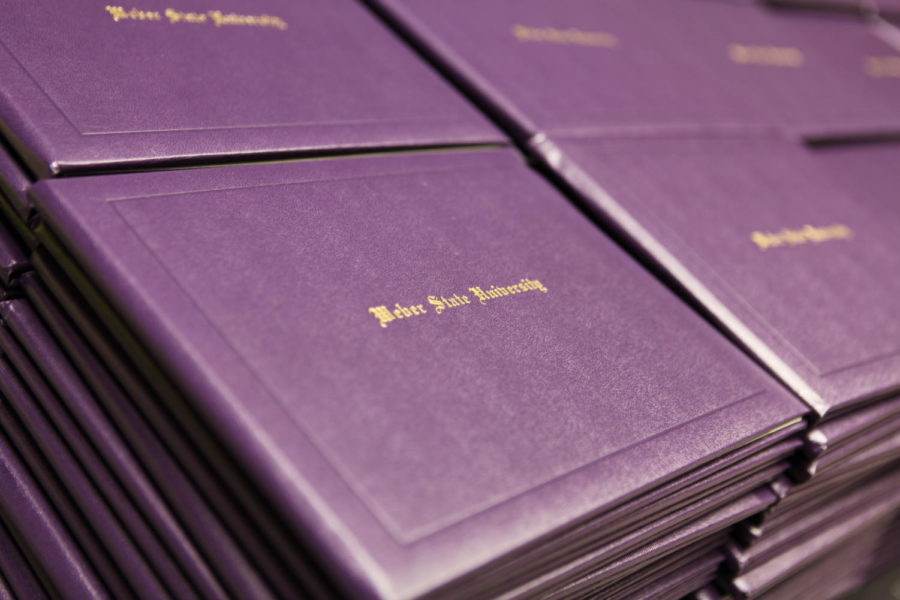 Purple Weber State University diploma cases stacked up and ready for their recipients.