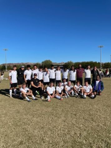 The mens soccer team poses for a photo on the soccer field.