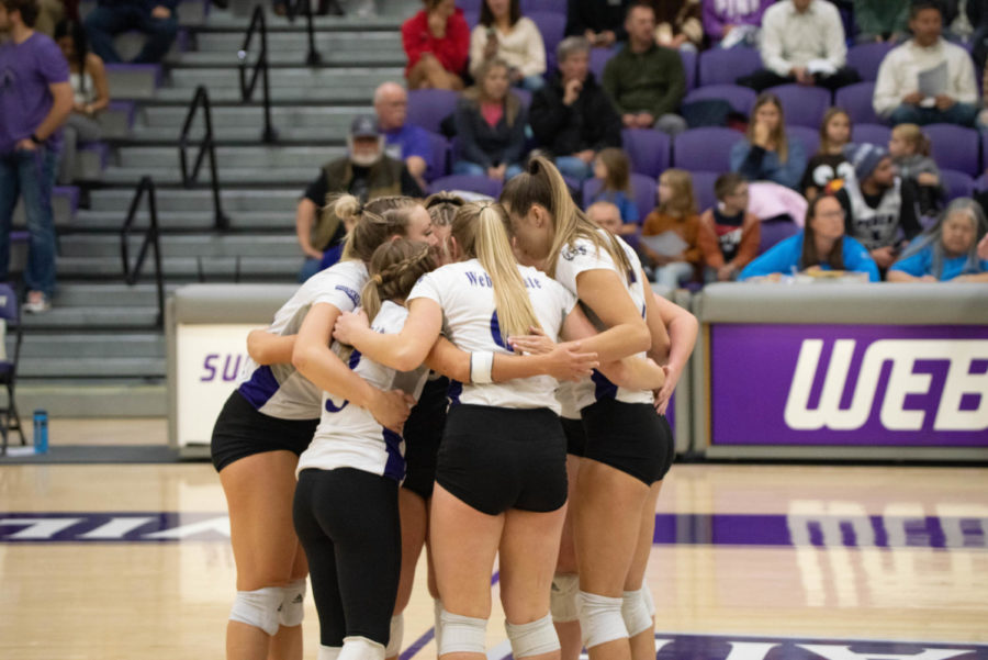 The Weber State volleyball team huddling together on the court.