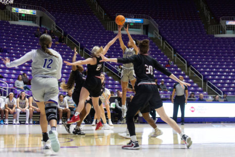 Daryn Hickok (21) aiming for the basket while EWU players attempt to stop her.