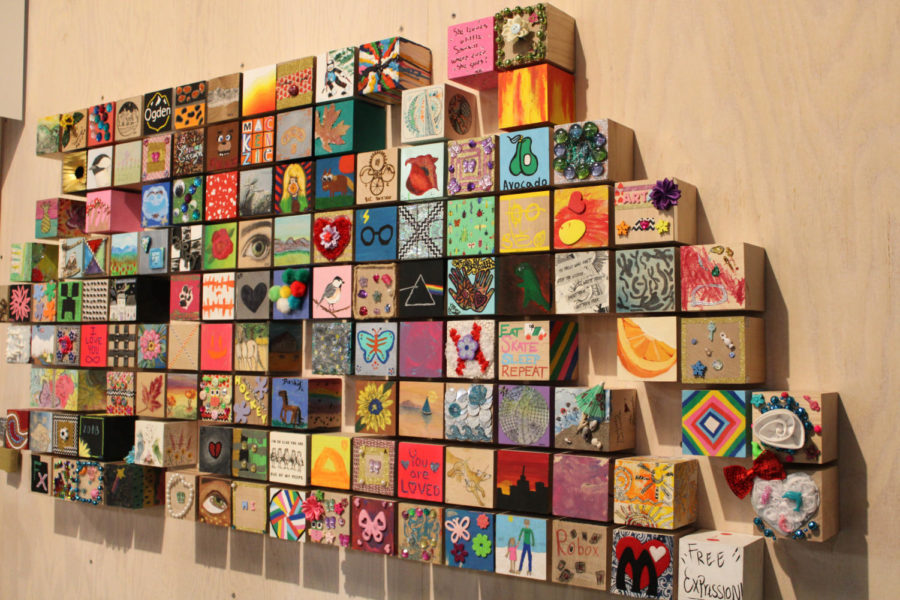 Painted cubes displayed on the wall from past visitors.
