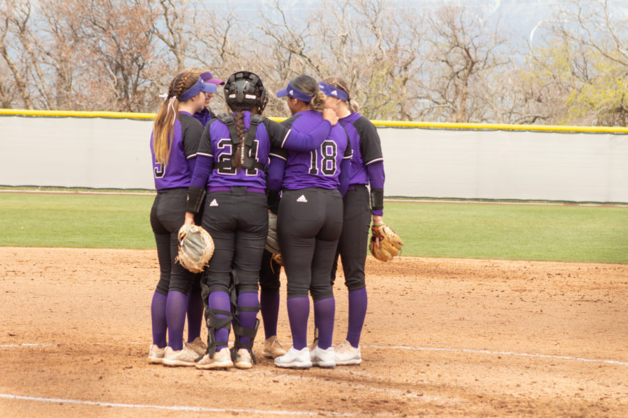 WSU womens softball players huddle together during a game in April 2022.