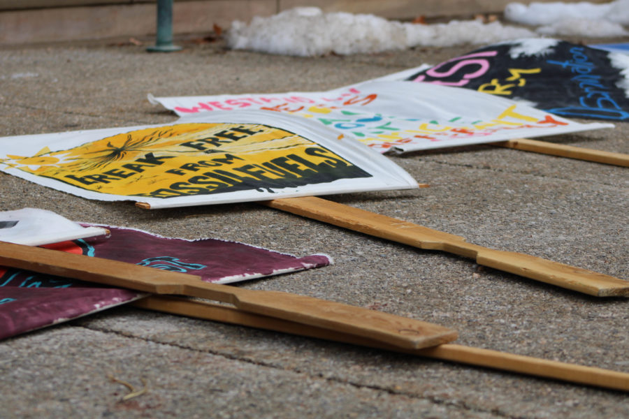Handmade protest signs lined up on the sidewalk for protestors to carry throughout the march.