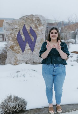 Emily Miller standing in front of the W rock at Weber State Univerity.
