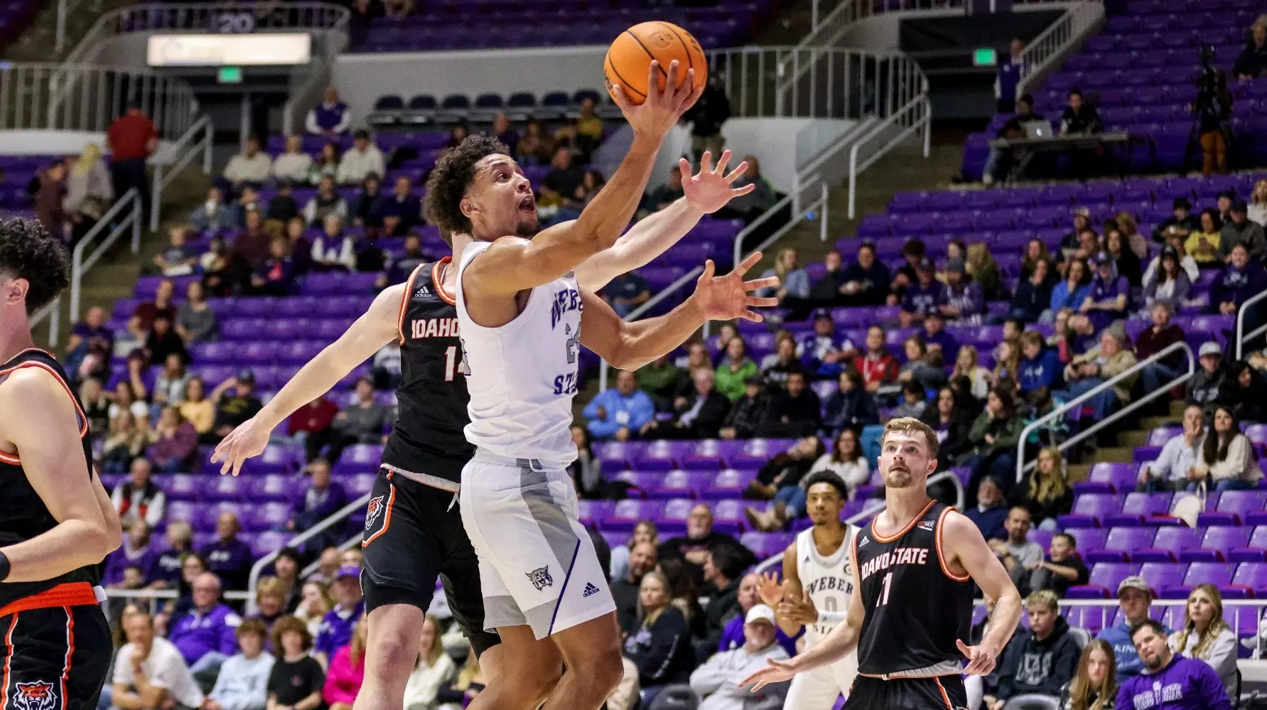 Weber State Mens Guard jumping to reach the ball before an opposing Idaho State player.